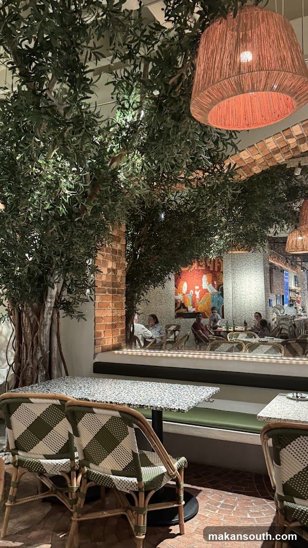 Interior of a restaurant or cafe with greenery and rattan furniture