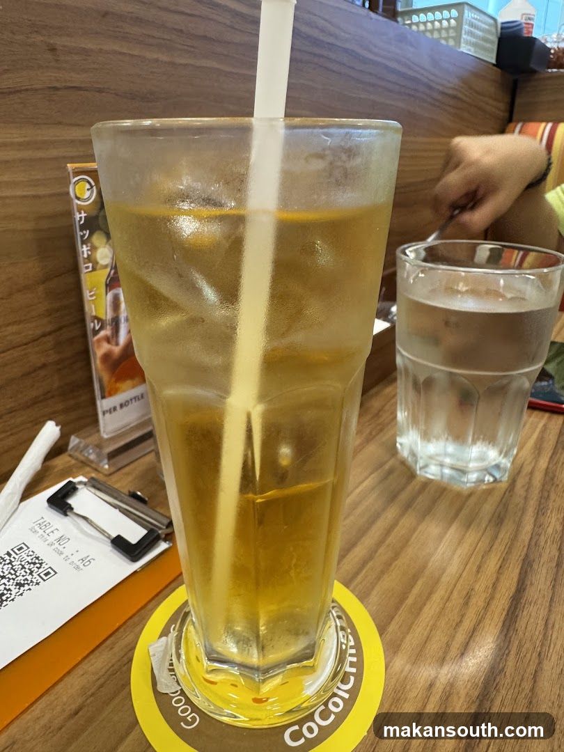 Iced beverage with straw and water glass on table