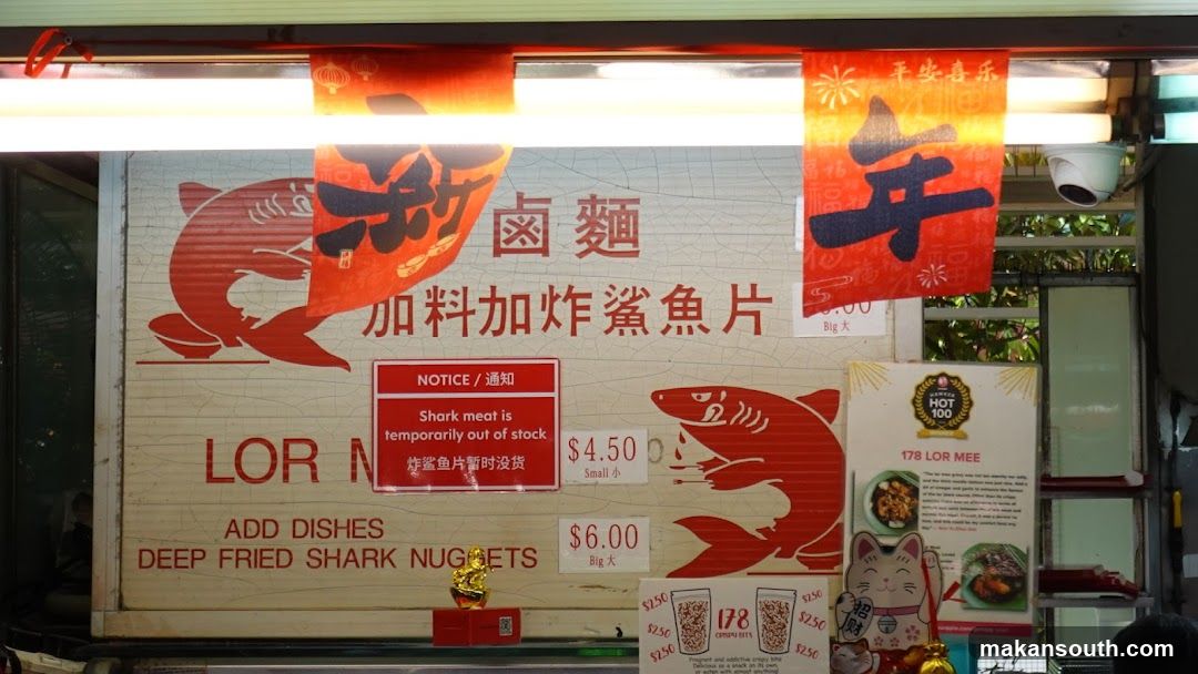 Food stall sign with shark graphics and menu items