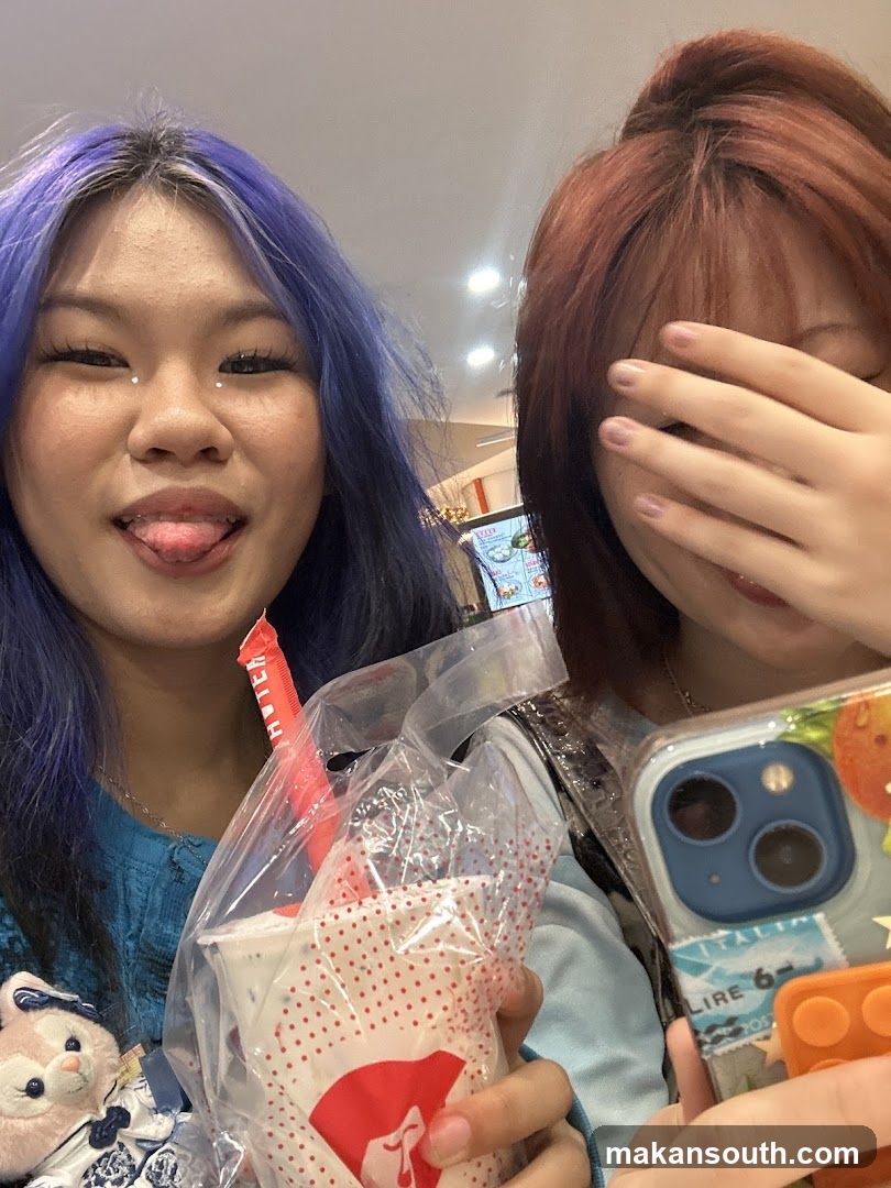 Two friends with drinks and phone case