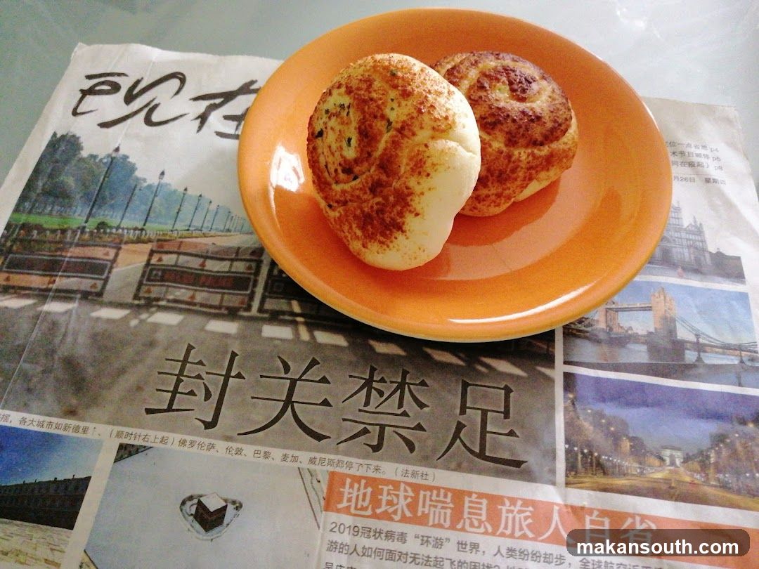 Buns on a plate atop newspaper