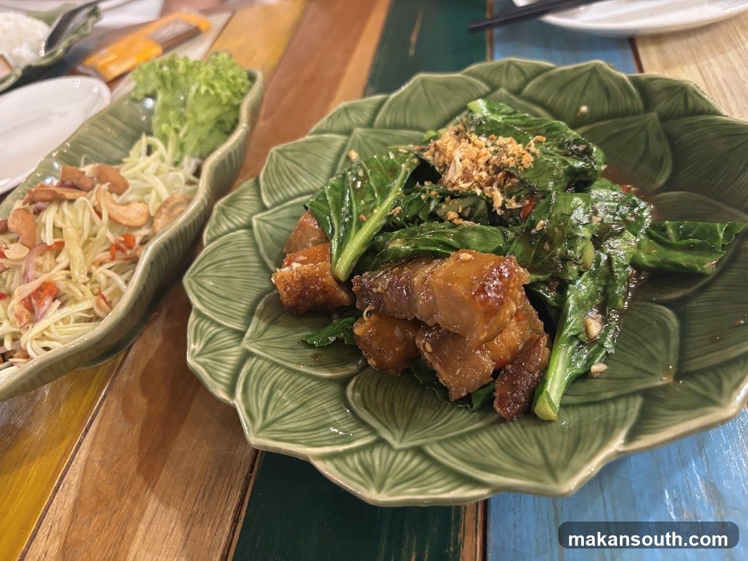 Dish with greens and pork belly