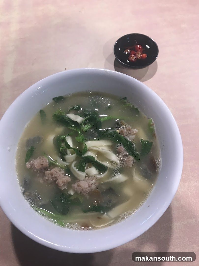 Bowl of Noodle Soup with Meat and Greens