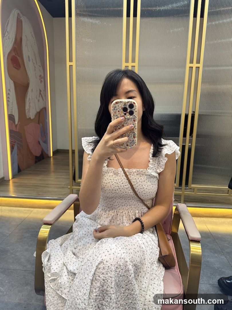 Woman in white dress taking mirror selfie