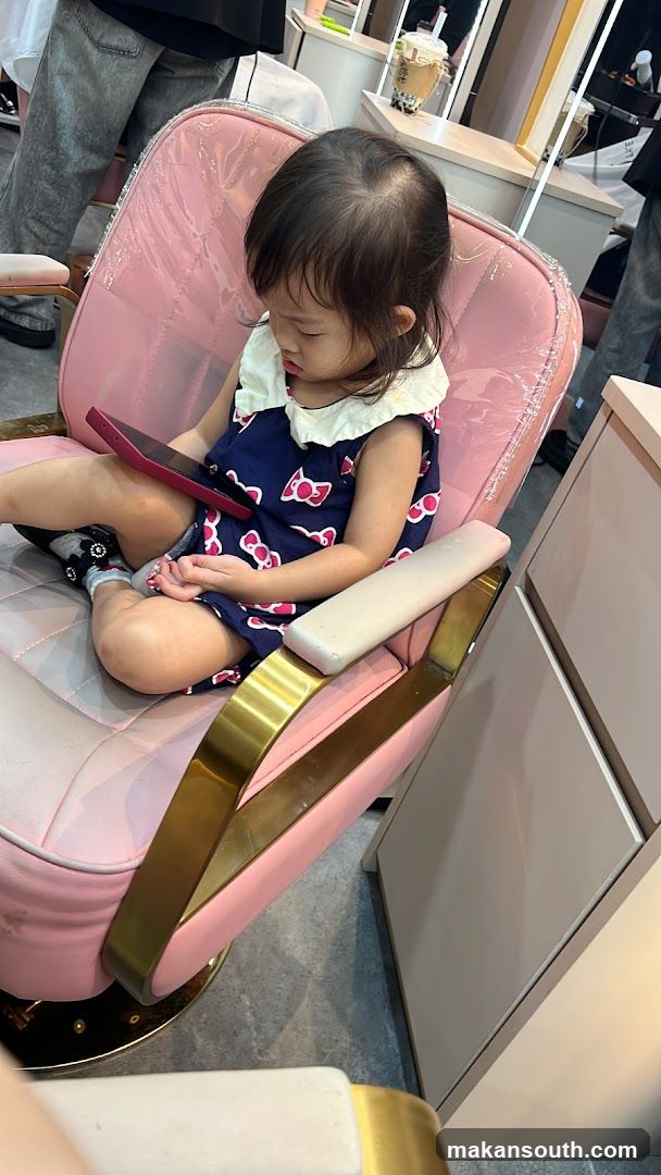 Child in Pink Chair with Phone