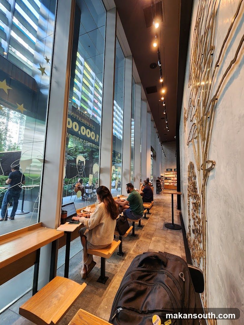 Interior of a modern café with large windows and patrons working or relaxing.