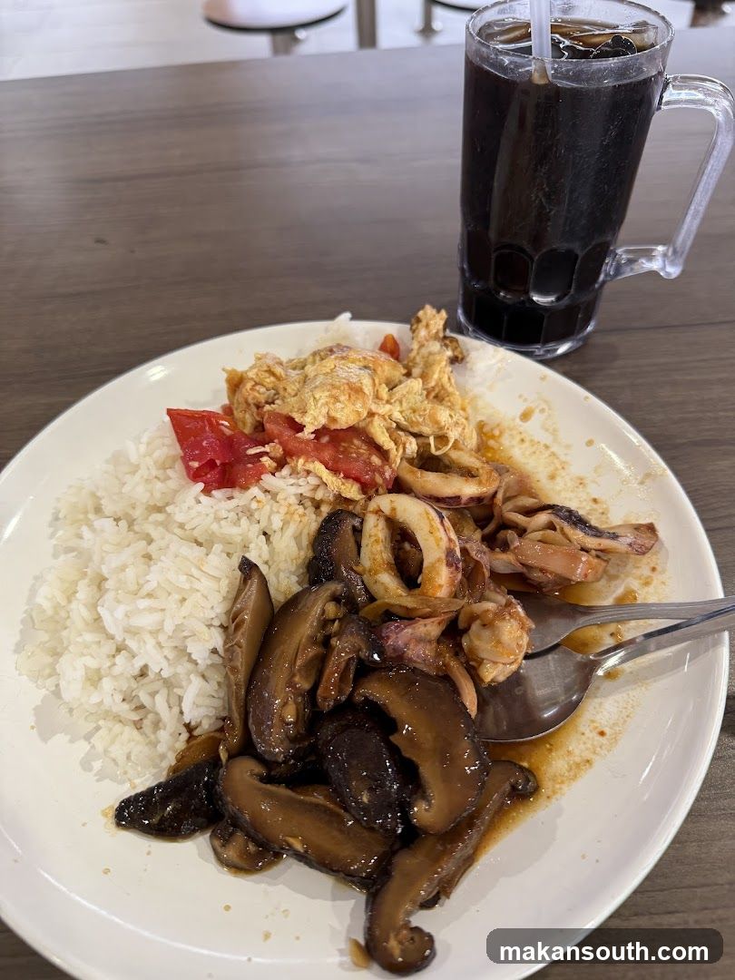 Plate of food with rice, mushrooms, squid and tomato eggs