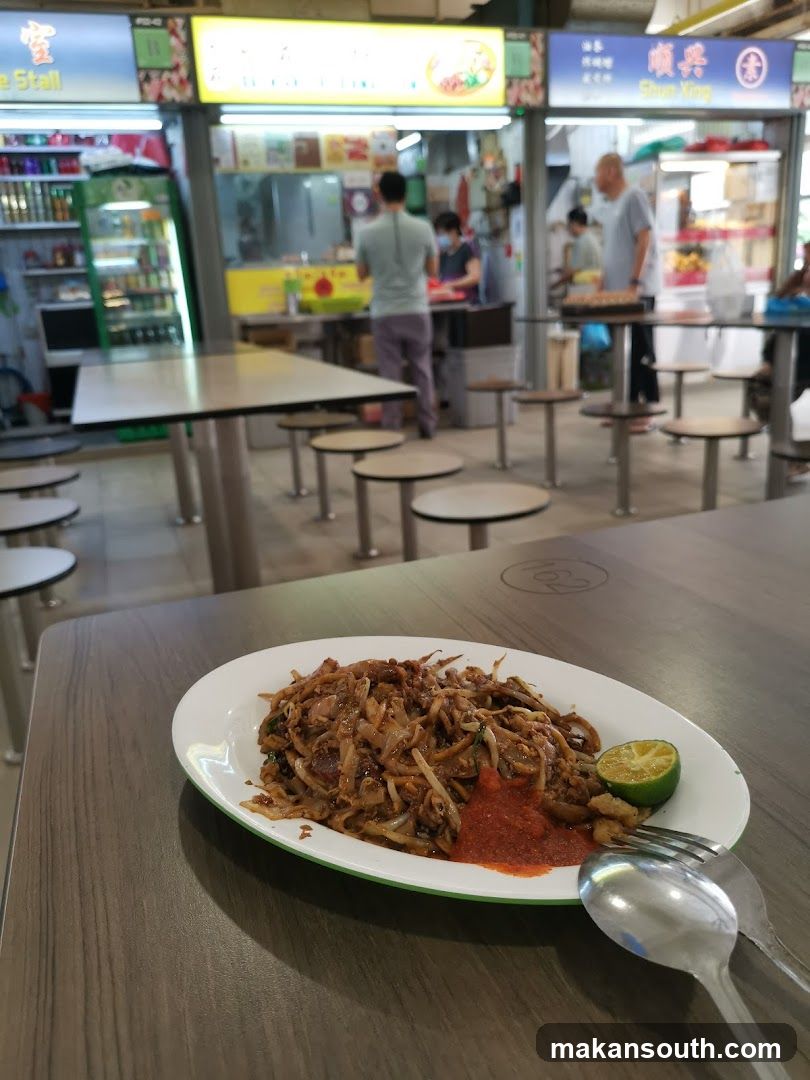 Food stall interior with plate of stir-fried noodles in foreground