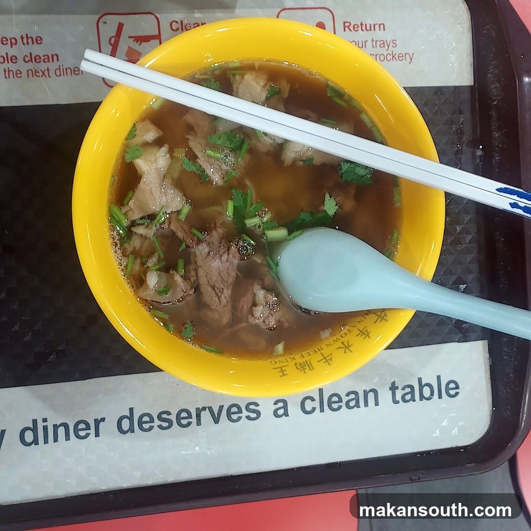 Bowl of Beef Soup with Chopsticks and Spoon
