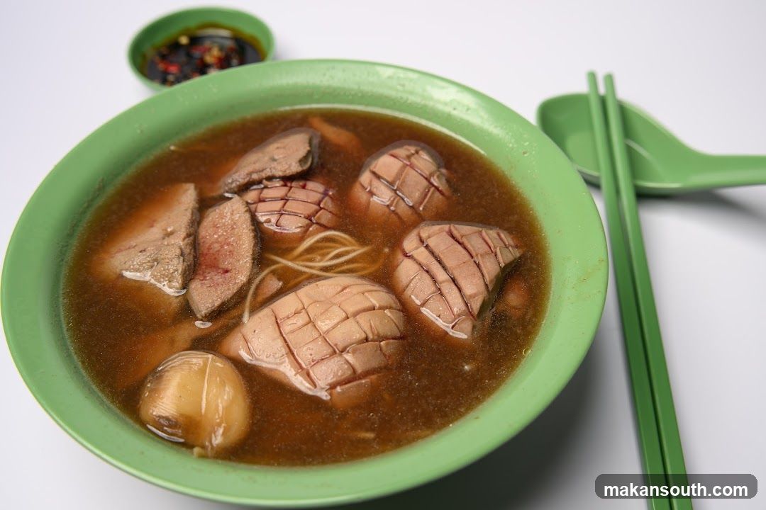 Bowl of Offal Soup with Green Bowl and Chopsticks