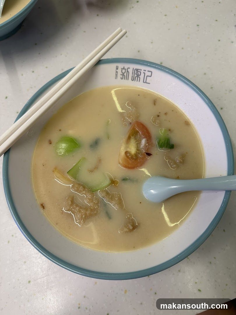 Bowl of creamy soup with chopsticks and spoon