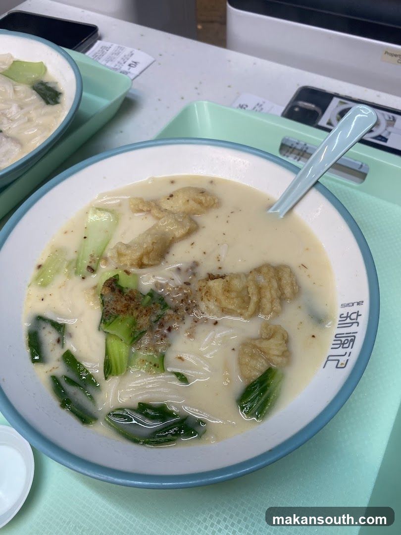 Bowl of Creamy Noodle Soup with Vegetables and Dumplings