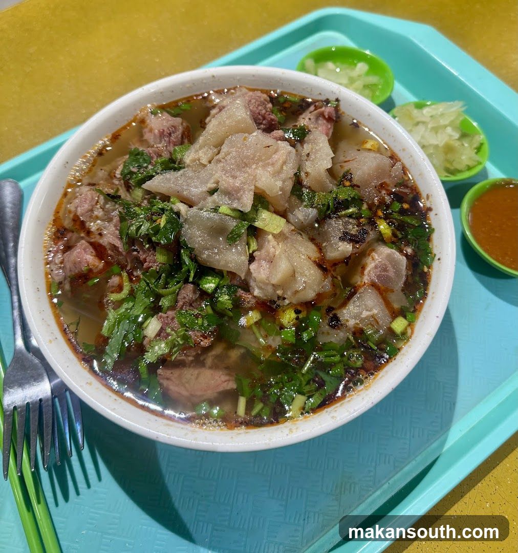 Bowl of Meat and Potato Soup with Condiments