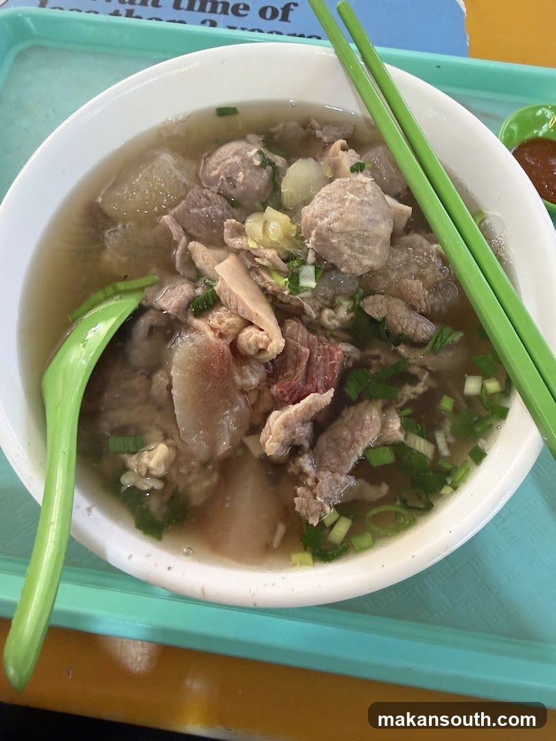 Bowl of Meat Soup with Green Utensils