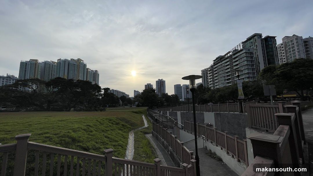 Sunset over urban park with high-rise buildings