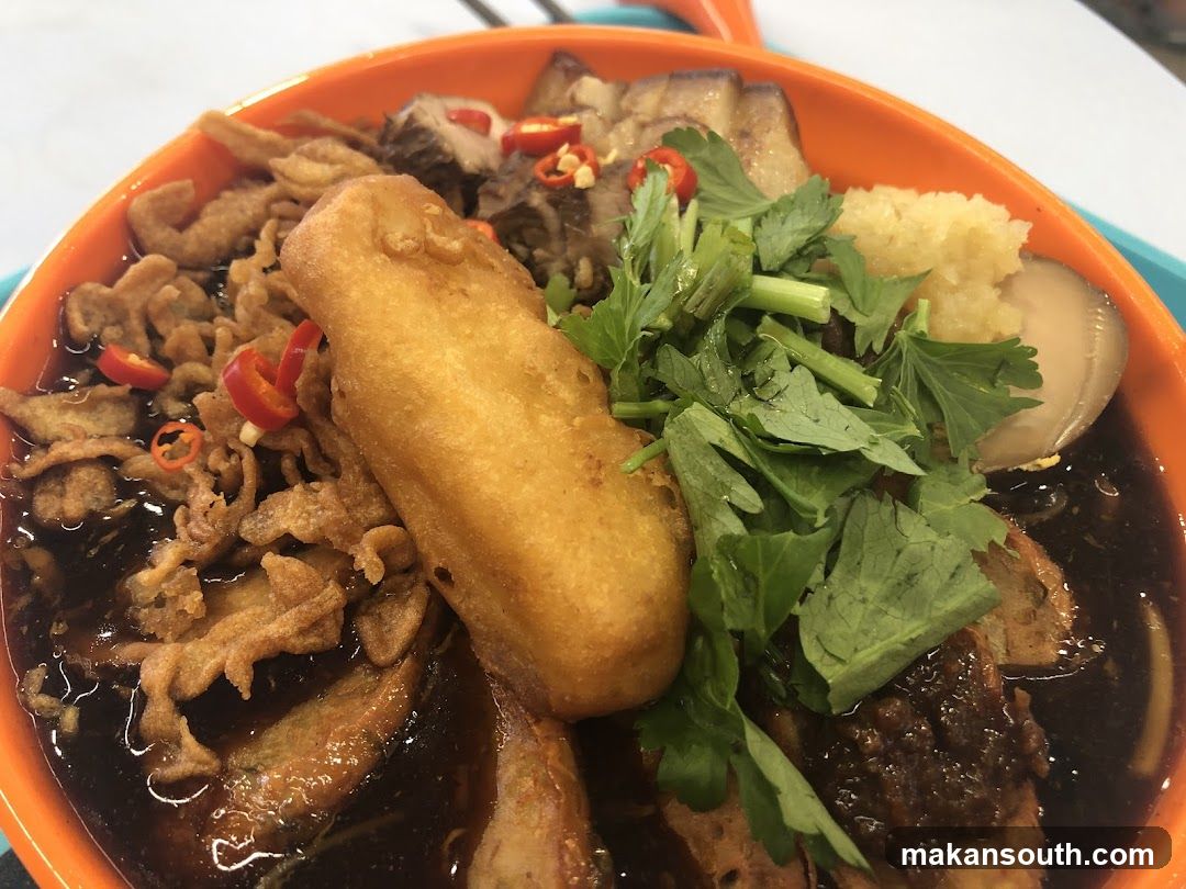 Bowl of Dark Broth with Fried Dough and Greens