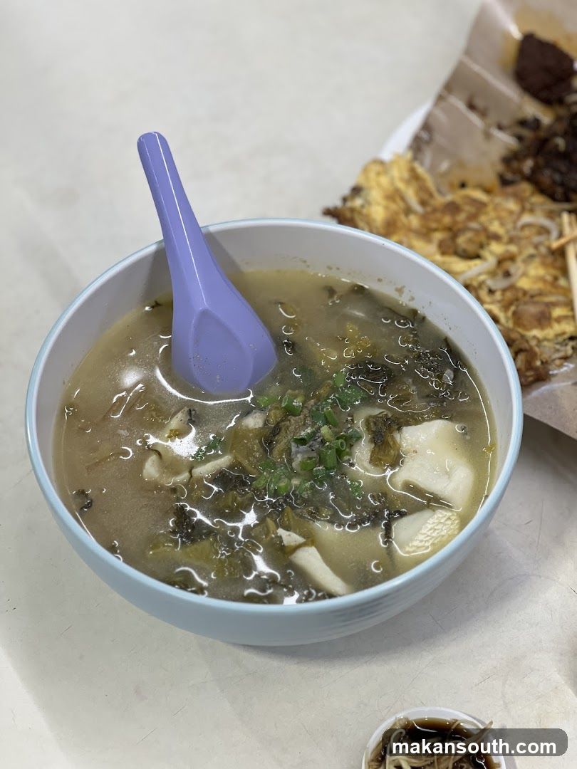 Bowl of Soup with Spoon and Side Dish