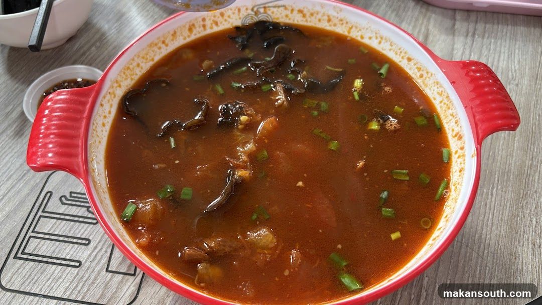 Red Soup Dish with Green Onions and Mushrooms