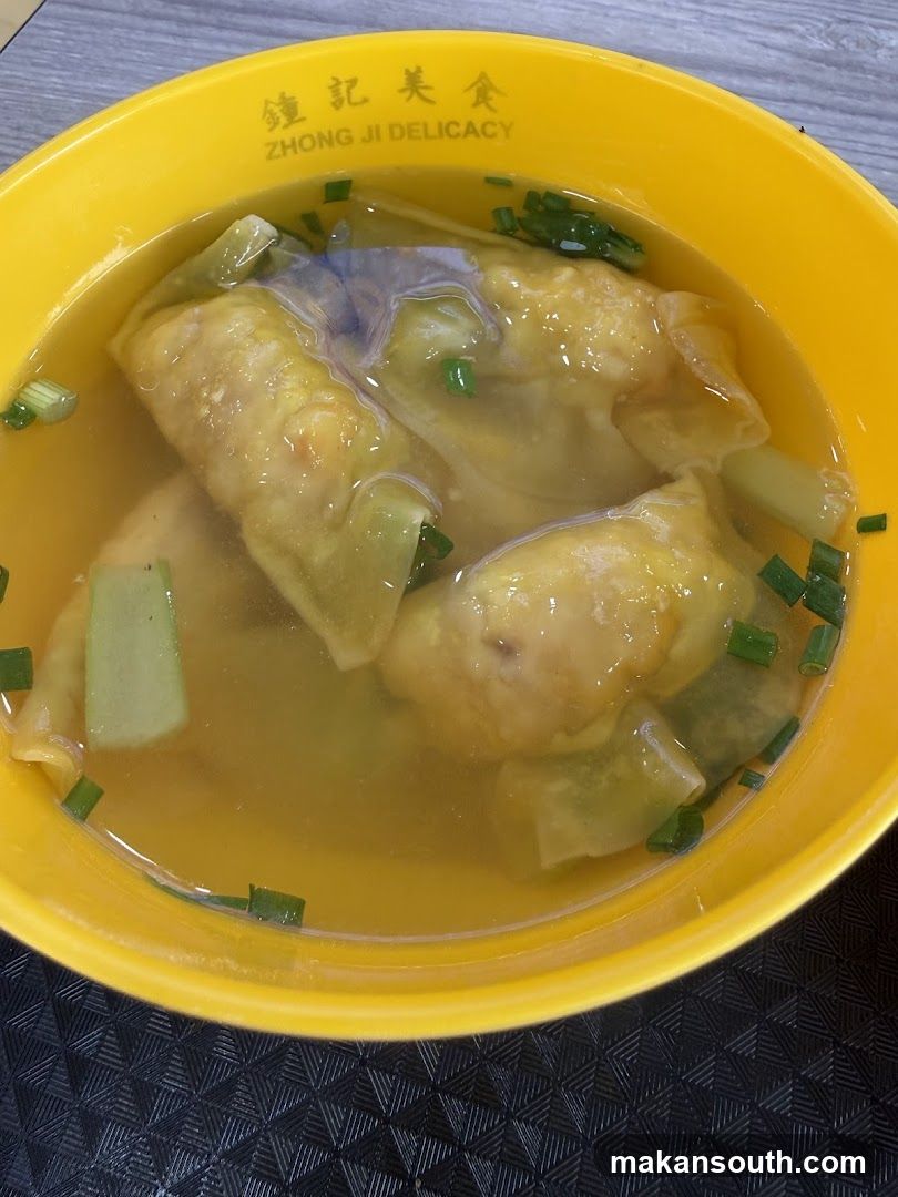 Bowl of wonton soup with vegetables and green onions