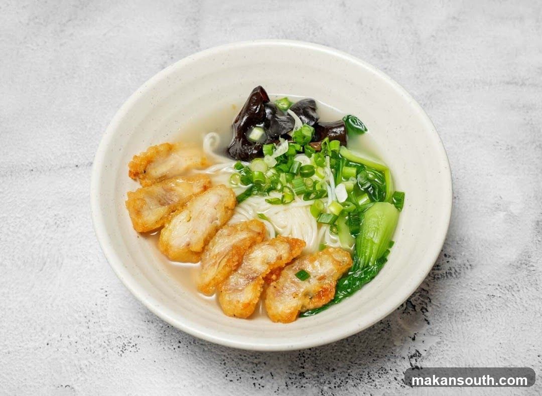 Bowl of Noodle Soup with Fried Chicken and Greens