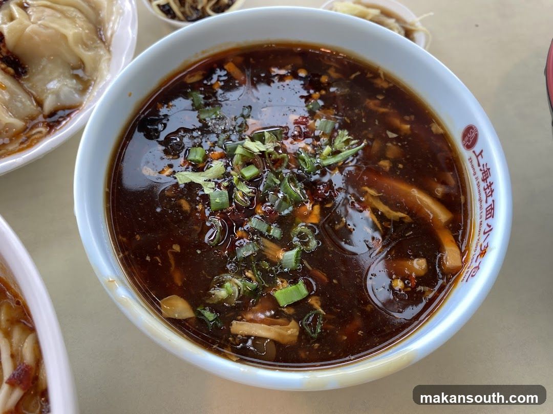 Bowl of spicy noodle soup with garnish