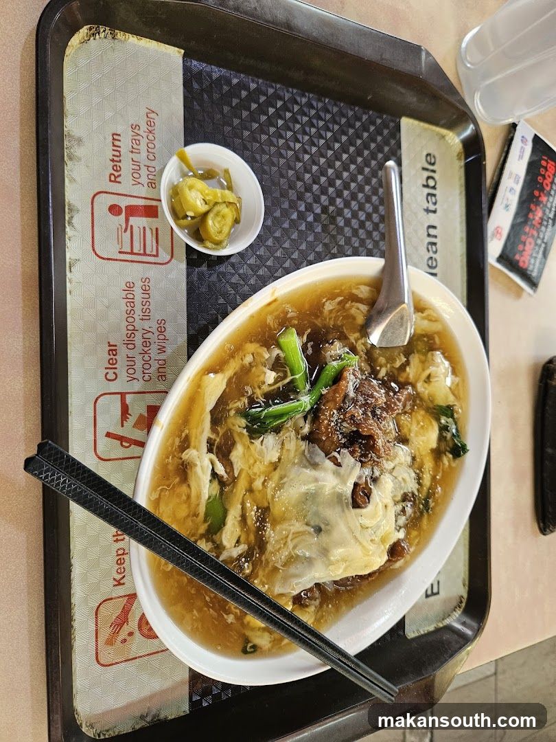 Bowl of soup with egg and greens on a tray