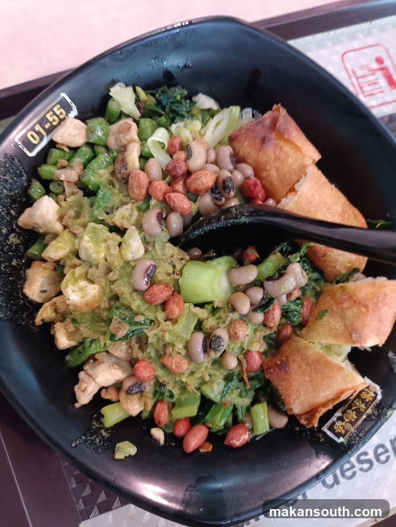 Bowl of food with rice, greens, beans, and fried dough