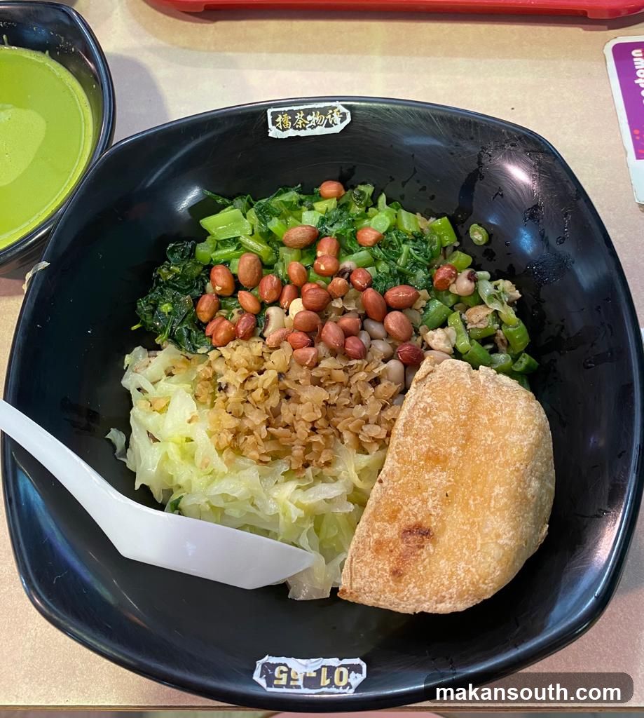 Bowl of food with greens, peanuts, and bread