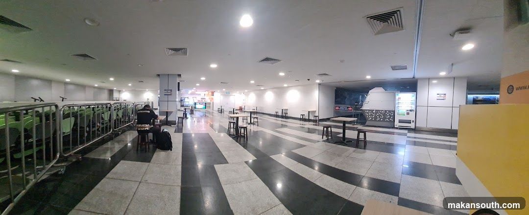 Empty indoor seating area with vending machines and tables