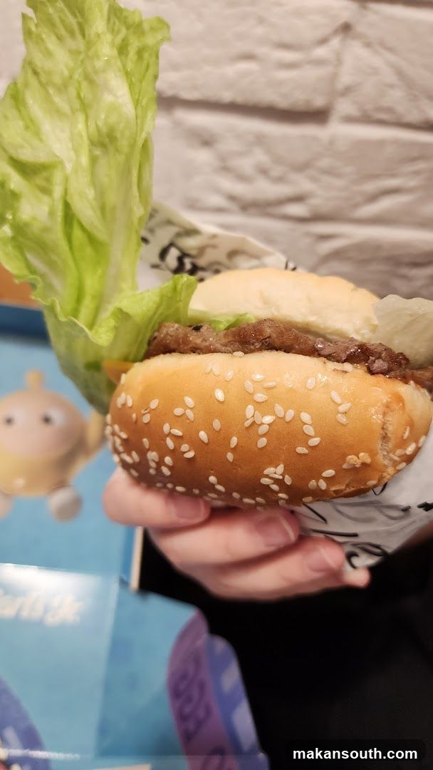 Hand Holding a Burger with Lettuce