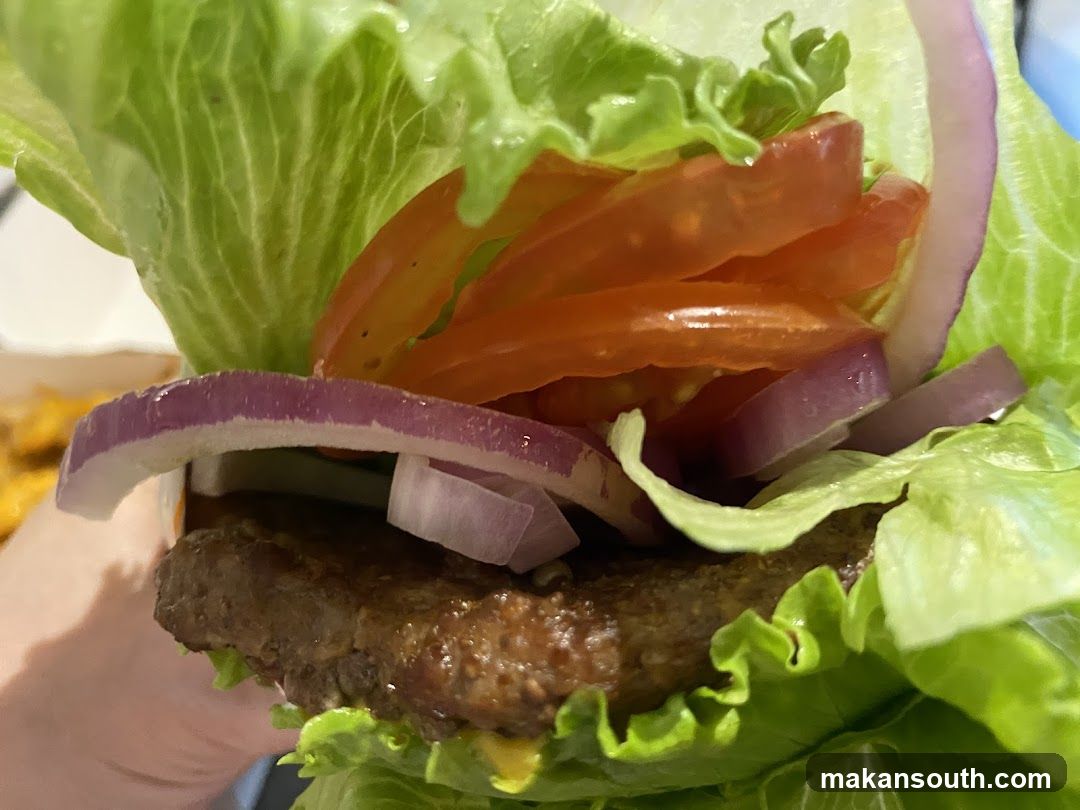 Burger with lettuce, tomato, and onion