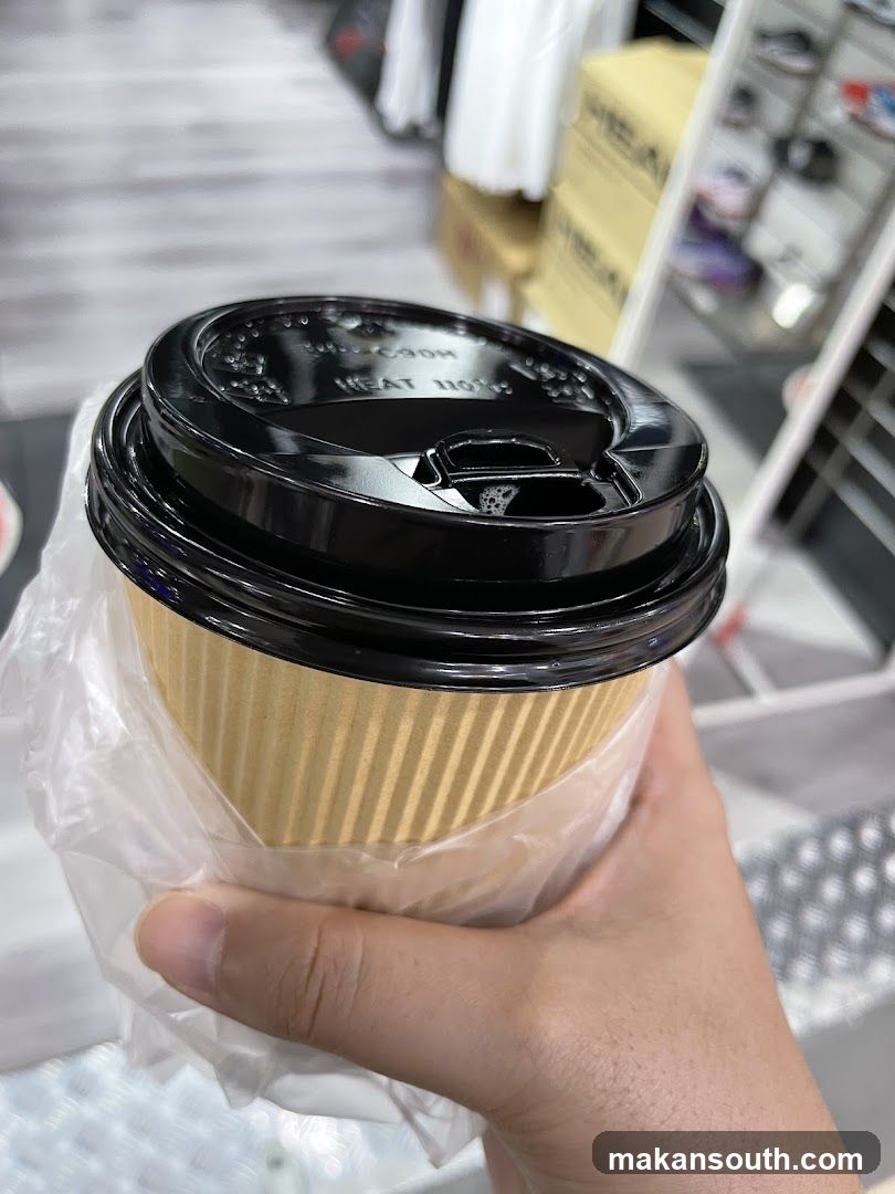Hand holding a takeaway coffee cup