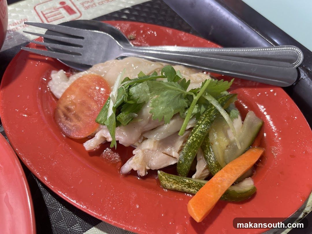 Chicken dish with vegetables on red plate