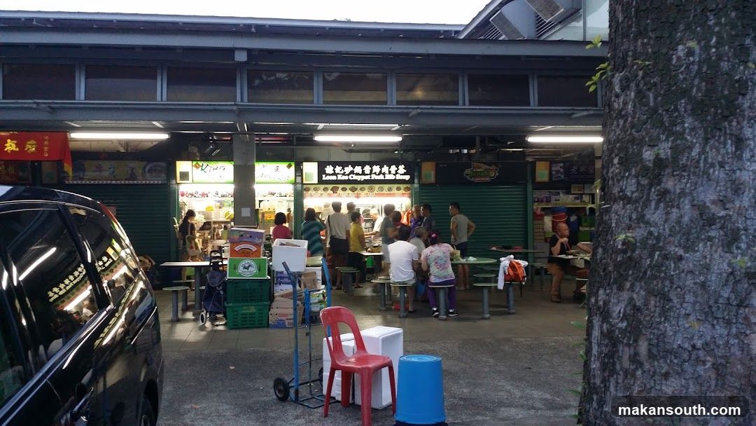 Food Stall Exterior with Diners and Stacks of Boxes