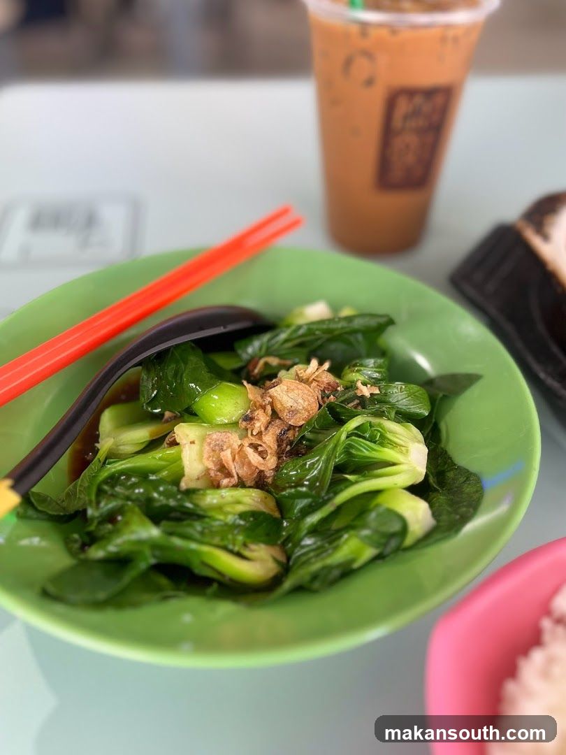 Bowl of stir-fried greens with fried garlic and iced coffee