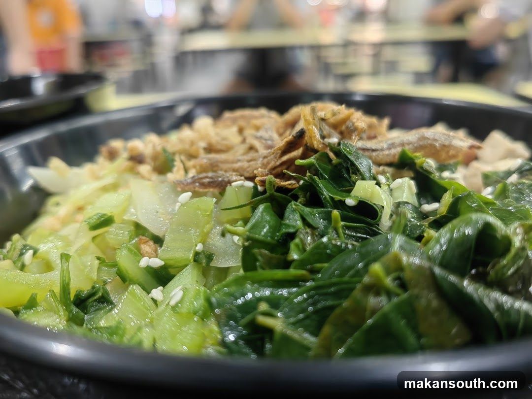 Bowl of stir-fried vegetables with fried fish