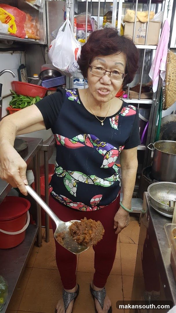 Woman in kitchen holding ladle with food