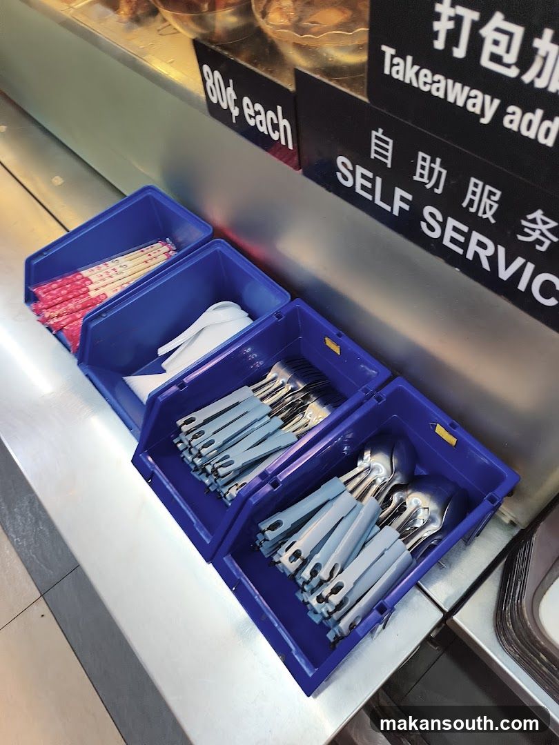 Blue plastic containers with cutlery and chopsticks on a counter