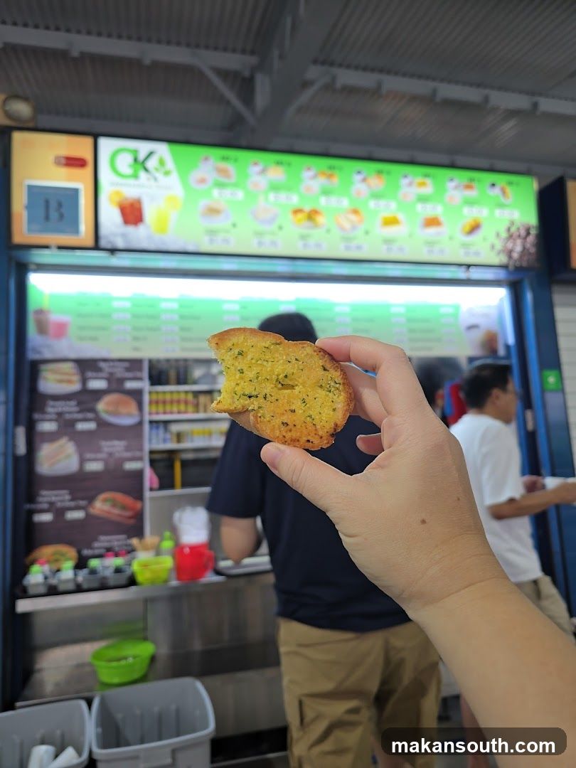 Hand holding garlic bread in food court