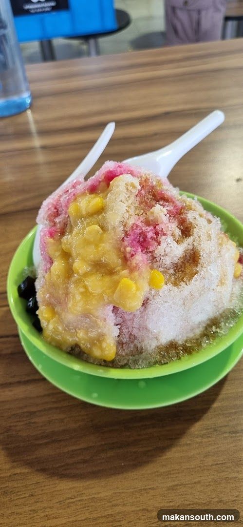 Bowl of shaved ice dessert with corn and syrup