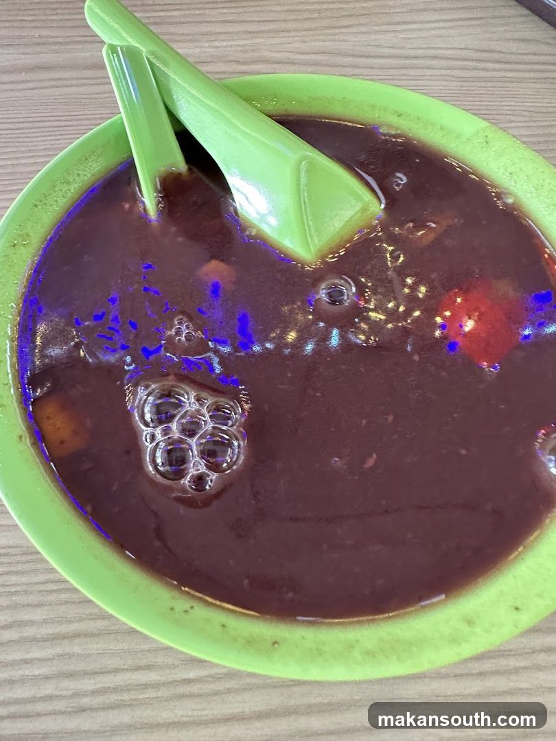 Bowl of Dark Soup with Green Spoons