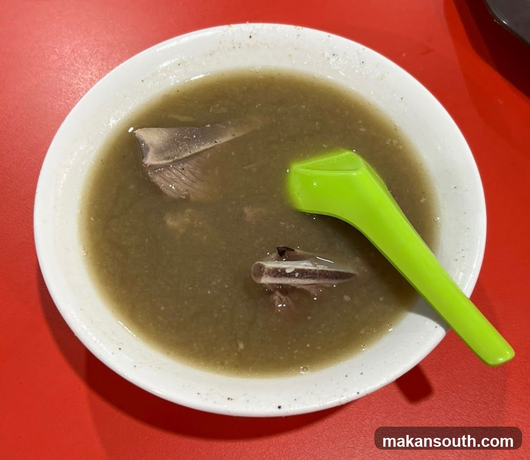 Bowl of Soup with Green Spoon