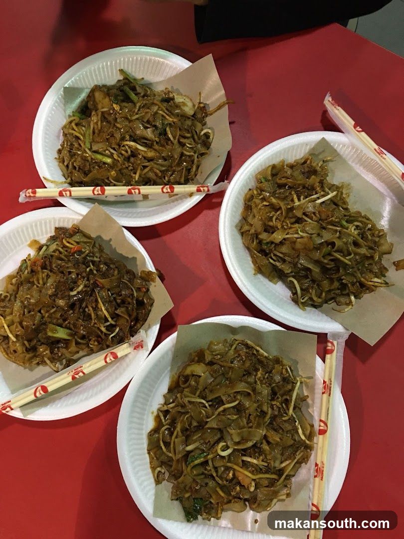 Four plates of stir-fried noodles on a red table