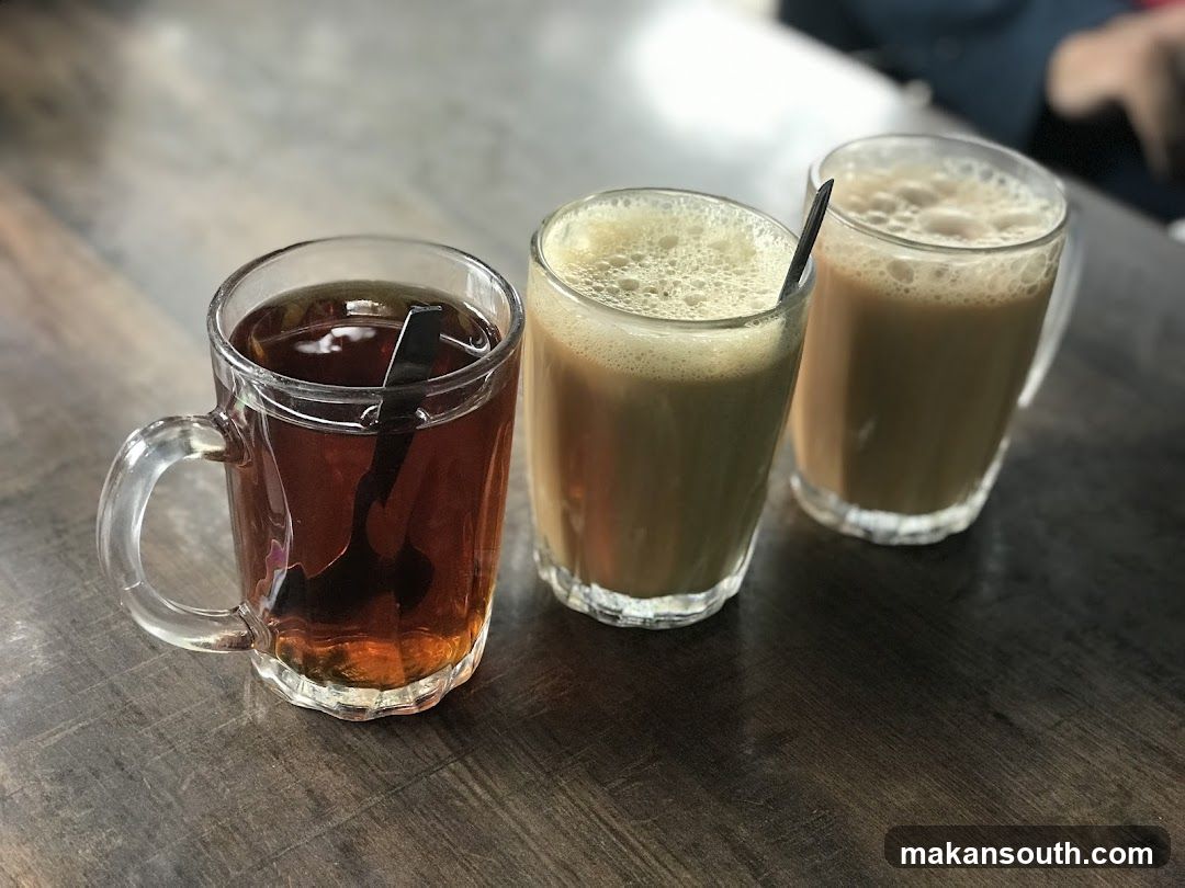 Three glasses of beverages on a wooden table