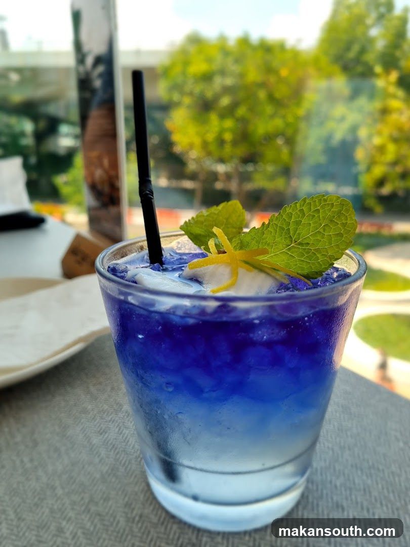 Blue Cocktail with Mint and Lemon Twist