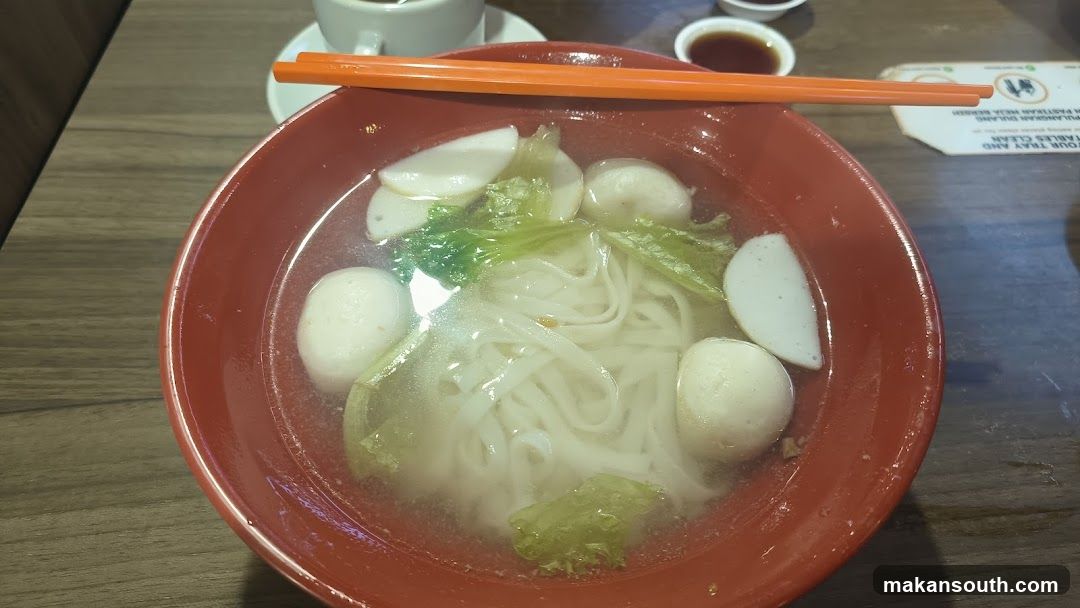 Bowl of Noodle Soup with Fish Balls and Lettuce