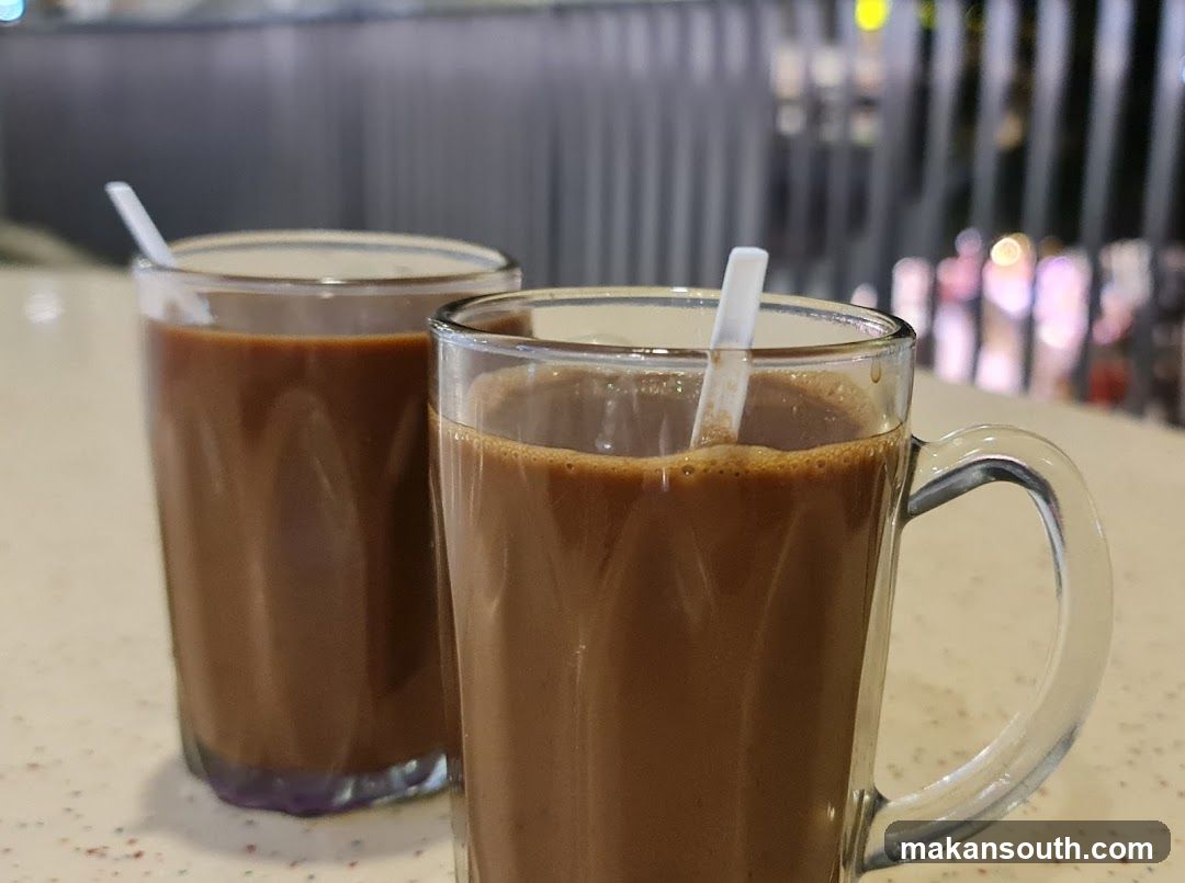 Two glasses of iced coffee with straws on a counter