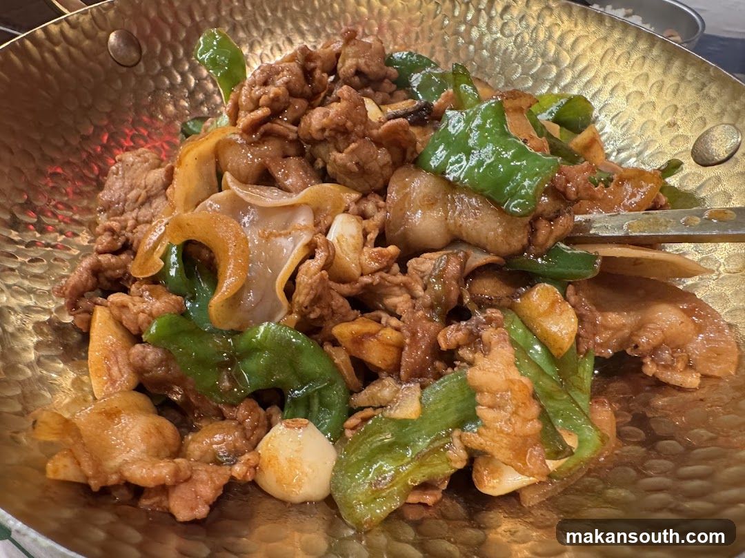 Stir-fried meat dish in a golden wok