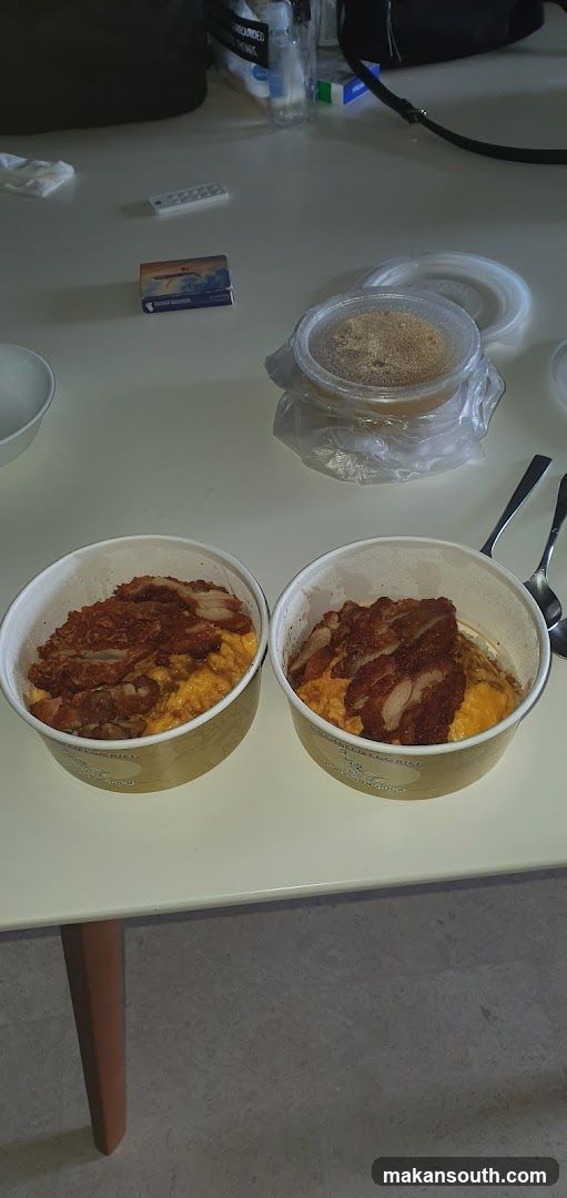 Two bowls of food with fried chicken and rice