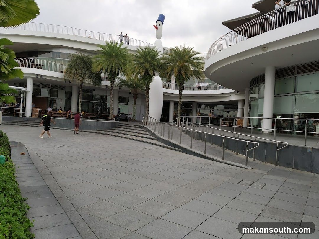 Modern building exterior with palm trees and people walking